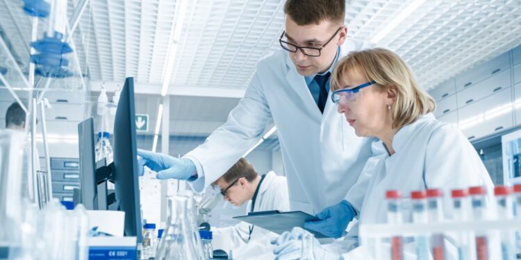 Two medical professionals conducting a round of research on new technologies. They're looking at a computer screen.