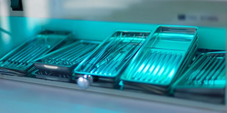 Rows of stacked trays full of reusable medical devices. They are inside the chamber of a sterilization machine.